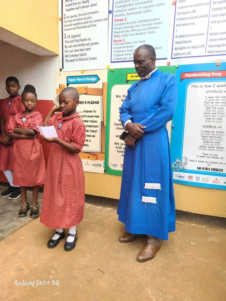 A priest standing with St. Keren pupils during a school activity