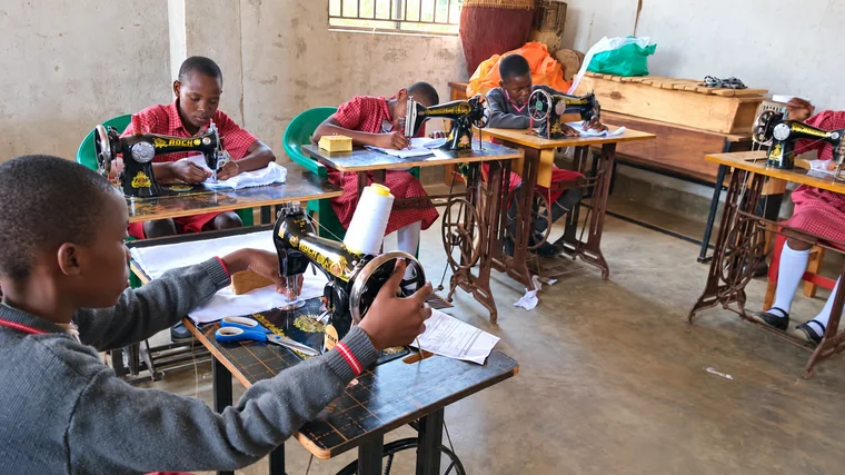 St. Keren pupils practising sewing with treadle machines